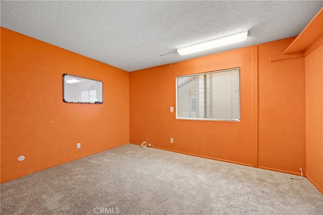 carpeted empty room featuring a textured ceiling