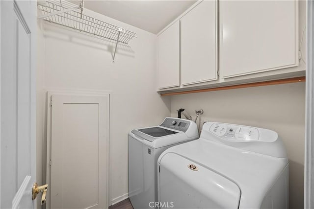 clothes washing area with washing machine and clothes dryer and cabinets