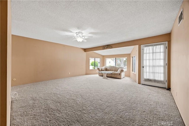 unfurnished living room featuring carpet, a textured ceiling, and ceiling fan