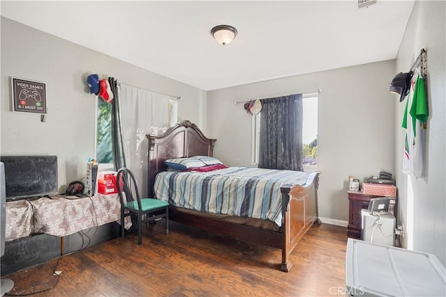 bedroom with dark hardwood / wood-style flooring