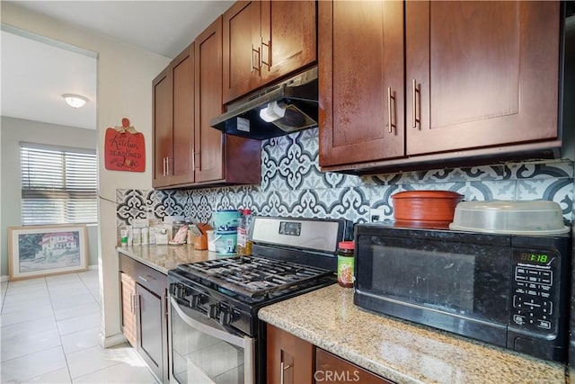 kitchen featuring light tile patterned flooring, gas stove, light stone counters, and tasteful backsplash