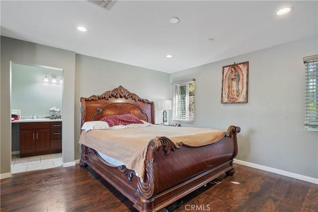 bedroom with ensuite bathroom, wood-type flooring, and sink