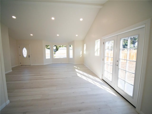 unfurnished living room featuring plenty of natural light, light hardwood / wood-style floors, and french doors