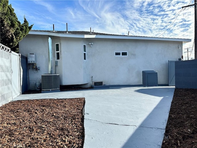 rear view of house with cooling unit and a patio