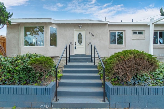 view of front of house with fence and stucco siding