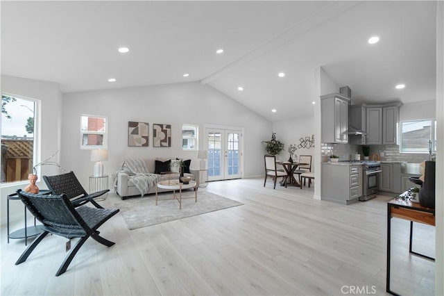 living area with light wood-type flooring, french doors, vaulted ceiling with beams, and recessed lighting