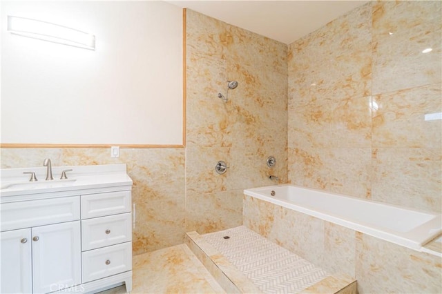 bathroom featuring tiled shower / bath combo, tile walls, and vanity