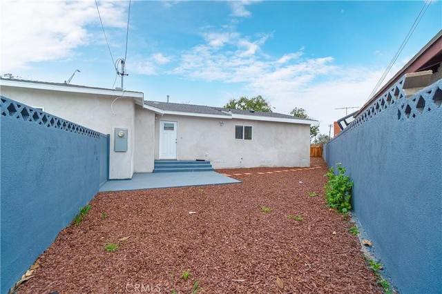 back of property featuring a patio, stucco siding, entry steps, crawl space, and a fenced backyard