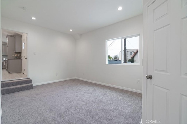 unfurnished room with recessed lighting, baseboards, and light colored carpet