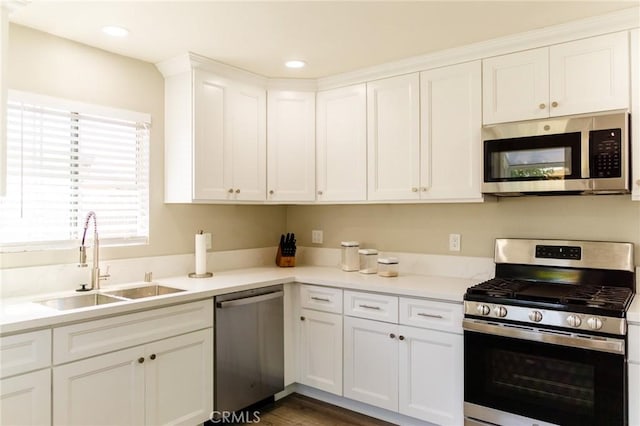 kitchen featuring dark hardwood / wood-style flooring, white cabinetry, sink, and appliances with stainless steel finishes