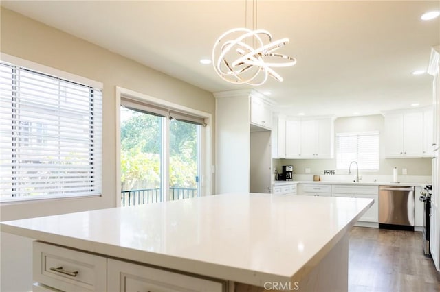 kitchen featuring dark hardwood / wood-style flooring, stainless steel dishwasher, a kitchen island, pendant lighting, and white cabinetry