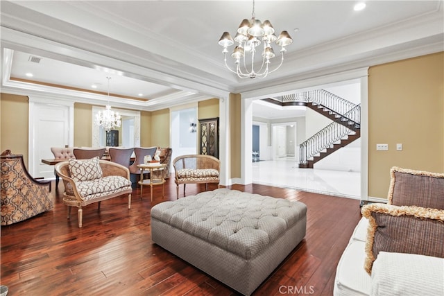 living room with a chandelier, a raised ceiling, and dark hardwood / wood-style flooring