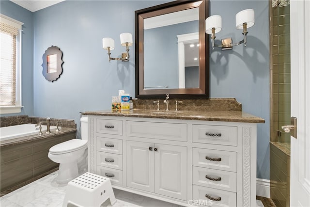 bathroom featuring vanity, toilet, and tiled bath