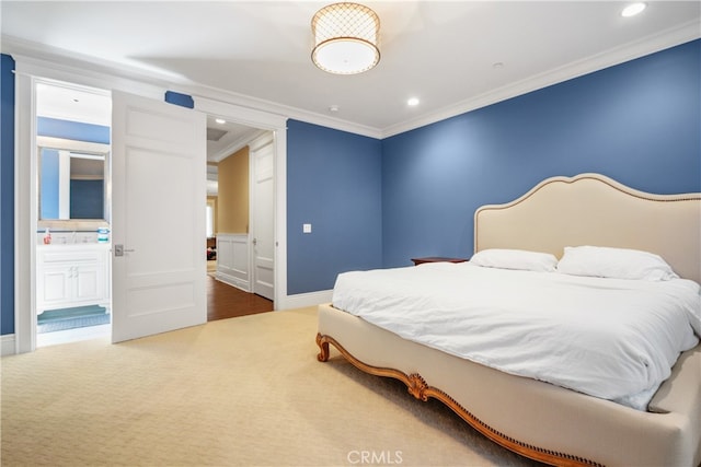 bedroom with crown molding, connected bathroom, and carpet