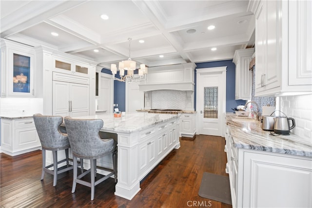 kitchen with a kitchen island, white cabinetry, hanging light fixtures, and tasteful backsplash