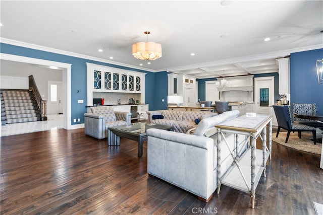 living room with coffered ceiling, beamed ceiling, dark wood-type flooring, ornamental molding, and an inviting chandelier