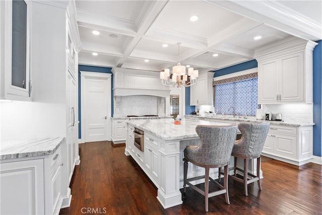 kitchen with dark hardwood / wood-style flooring, white cabinetry, pendant lighting, and a kitchen island