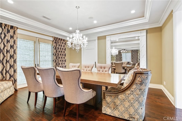 dining space with crown molding, a chandelier, dark wood-type flooring, and a raised ceiling