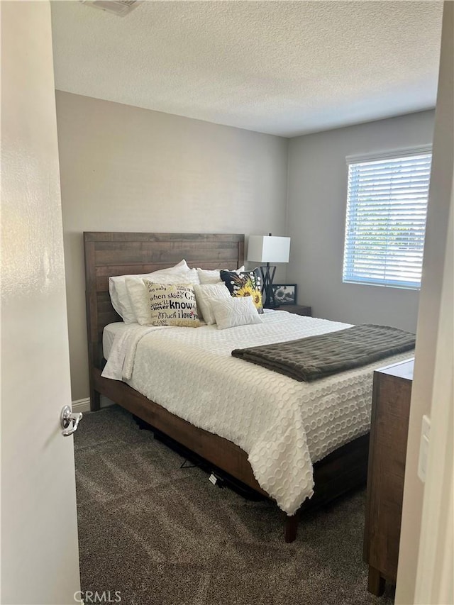 carpeted bedroom with a textured ceiling