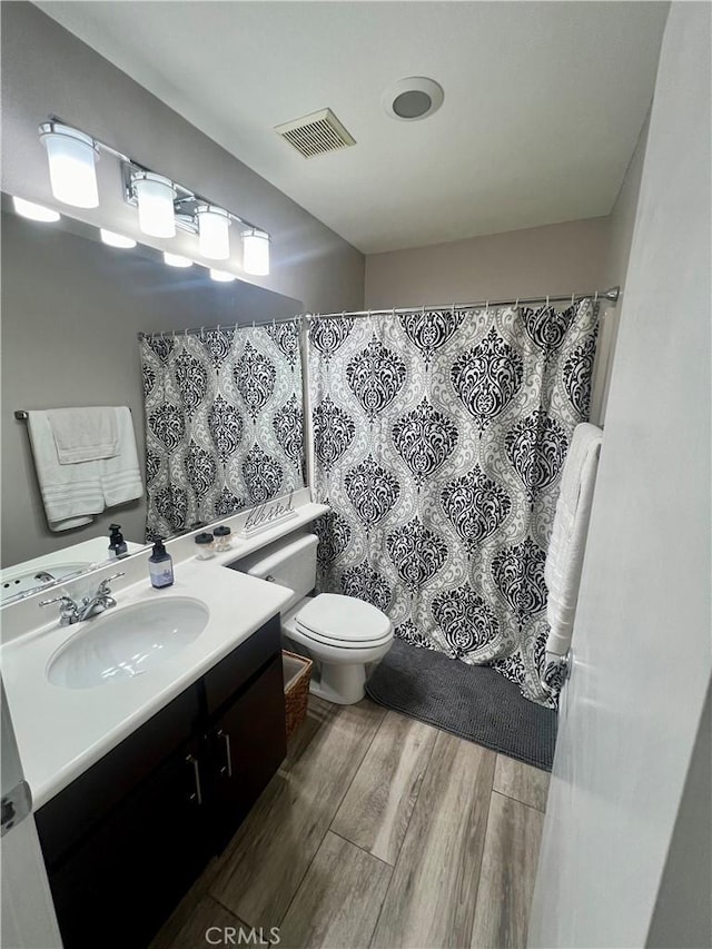 bathroom featuring vanity, hardwood / wood-style flooring, and toilet