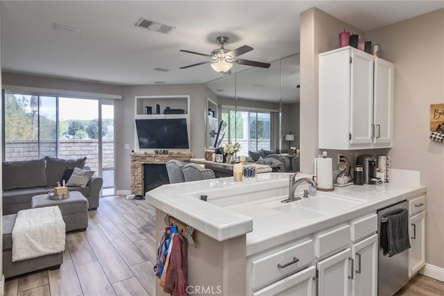 23014 Cheyenne Dr Unit 151, Valencia, CA 91354 - kitchen featuring open floor plan, dishwasher, a sink, white cabinetry, and ceiling fan