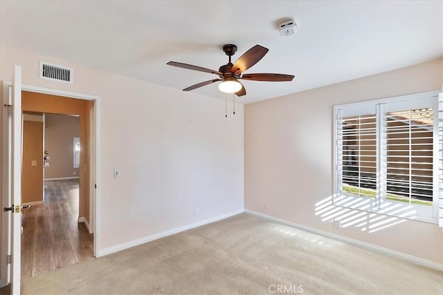 carpeted spare room with ceiling fan