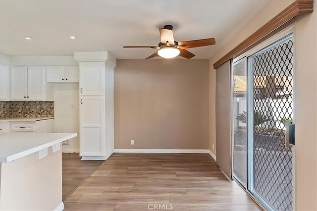 kitchen with decorative backsplash, light hardwood / wood-style floors, white cabinetry, and ceiling fan