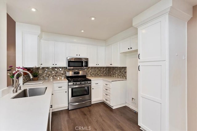 kitchen with white cabinetry, sink, stainless steel appliances, tasteful backsplash, and dark hardwood / wood-style floors