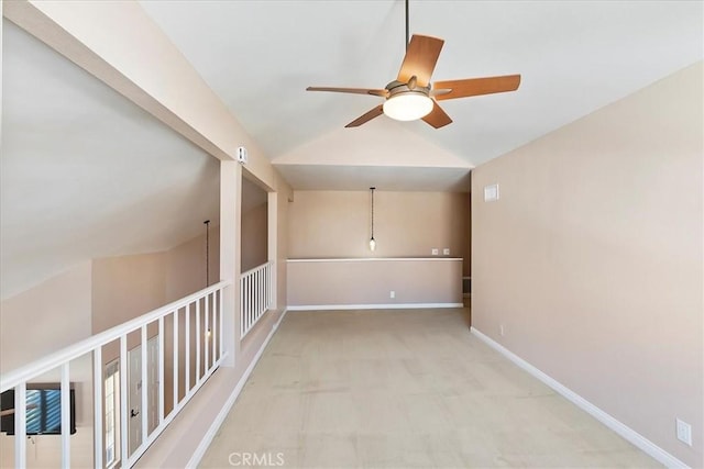 carpeted spare room with ceiling fan and lofted ceiling