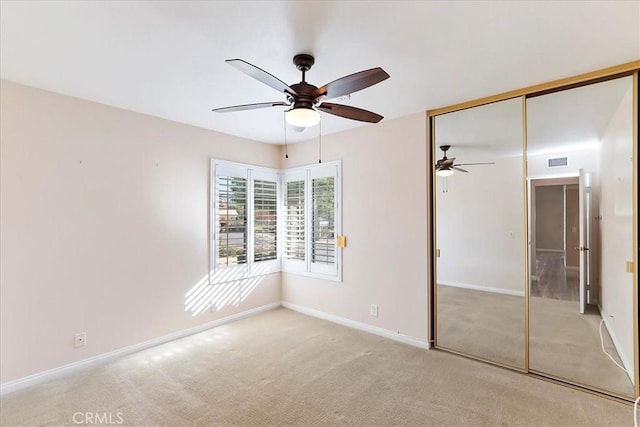 unfurnished bedroom featuring a closet, ceiling fan, and light colored carpet