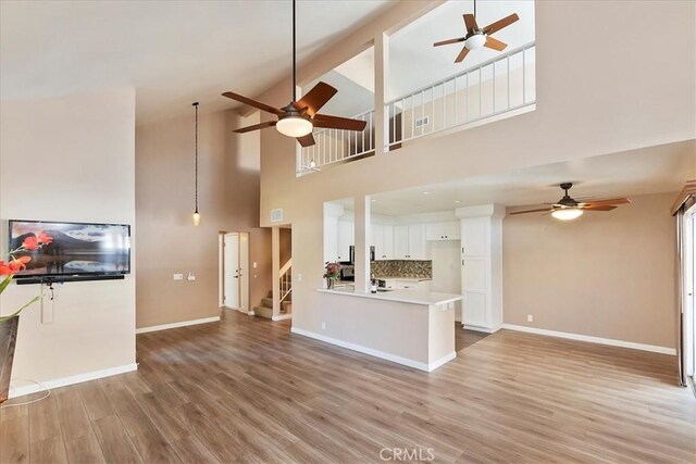 unfurnished living room with high vaulted ceiling and hardwood / wood-style flooring