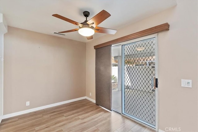 empty room with ceiling fan and light hardwood / wood-style flooring