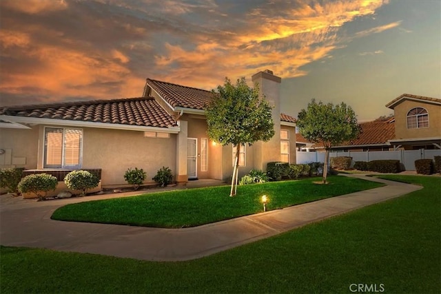 mediterranean / spanish-style home with a lawn