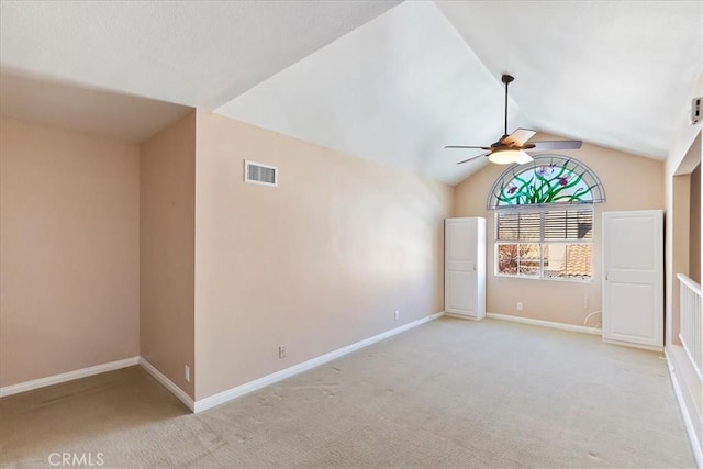 carpeted spare room featuring ceiling fan and lofted ceiling