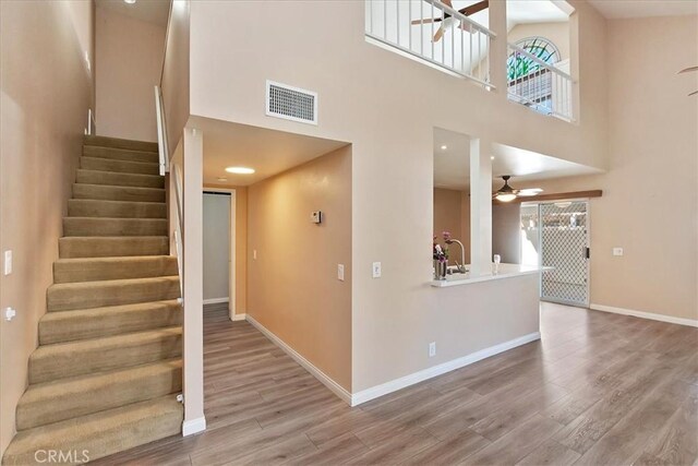 stairway with a high ceiling, hardwood / wood-style flooring, and plenty of natural light