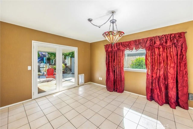 spare room featuring light tile patterned floors and french doors