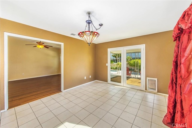 unfurnished room featuring french doors, light wood-type flooring, and ceiling fan