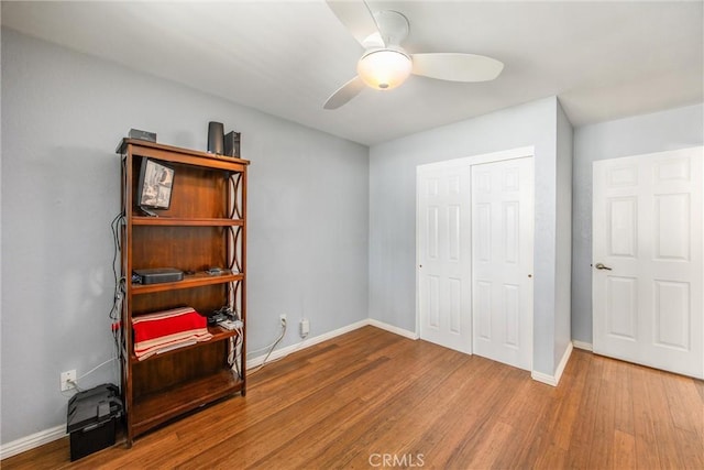 bedroom with ceiling fan, wood-type flooring, and a closet