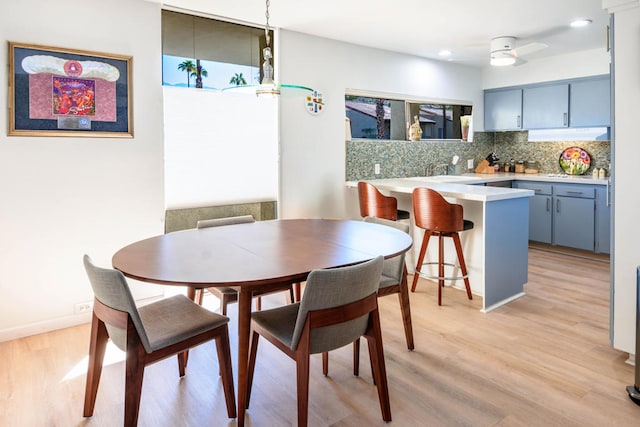 dining area with light hardwood / wood-style floors and ceiling fan