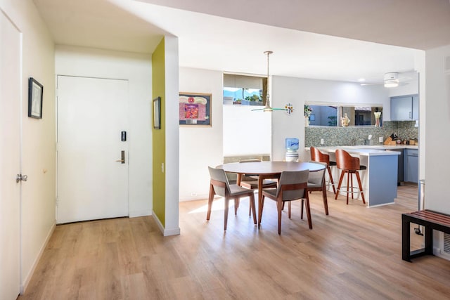 dining space with light wood-type flooring and ceiling fan