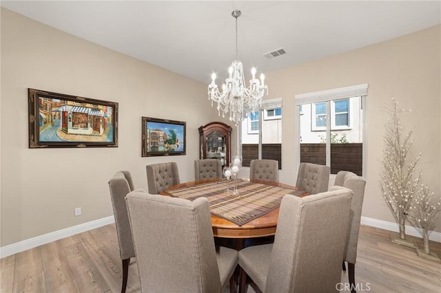 dining area featuring light hardwood / wood-style floors and an inviting chandelier