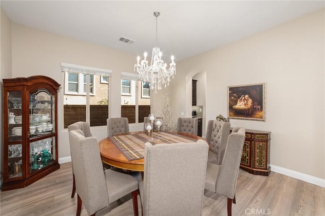 dining room featuring light hardwood / wood-style flooring and a notable chandelier