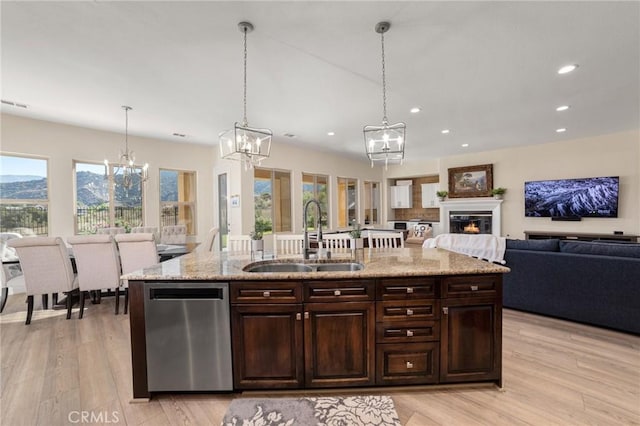 kitchen featuring hanging light fixtures, a wealth of natural light, sink, and stainless steel dishwasher