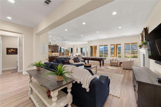 living room with billiards and light hardwood / wood-style flooring