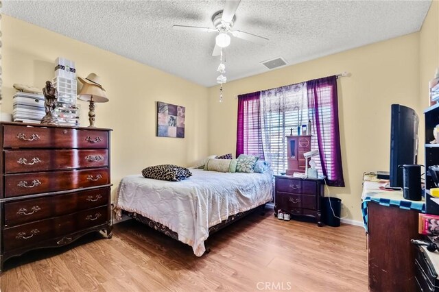 6277 Linda Lee Dr, Yucca Valley, CA 92284 - bedroom with wood finished floors, a textured ceiling, a ceiling fan, and baseboards