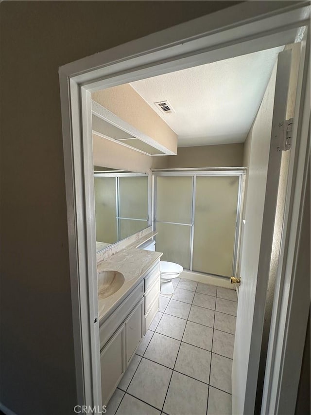 full bathroom with a stall shower, visible vents, tile patterned floors, a textured ceiling, and vanity