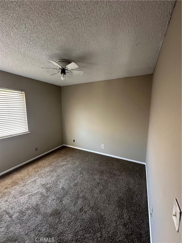 carpeted empty room featuring ceiling fan, a textured ceiling, and baseboards