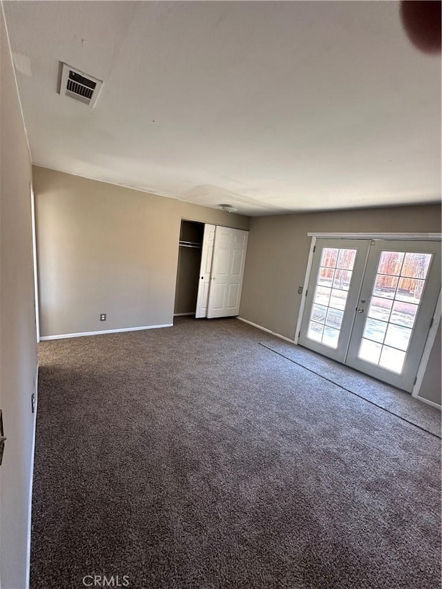 unfurnished room featuring baseboards, visible vents, dark colored carpet, and french doors