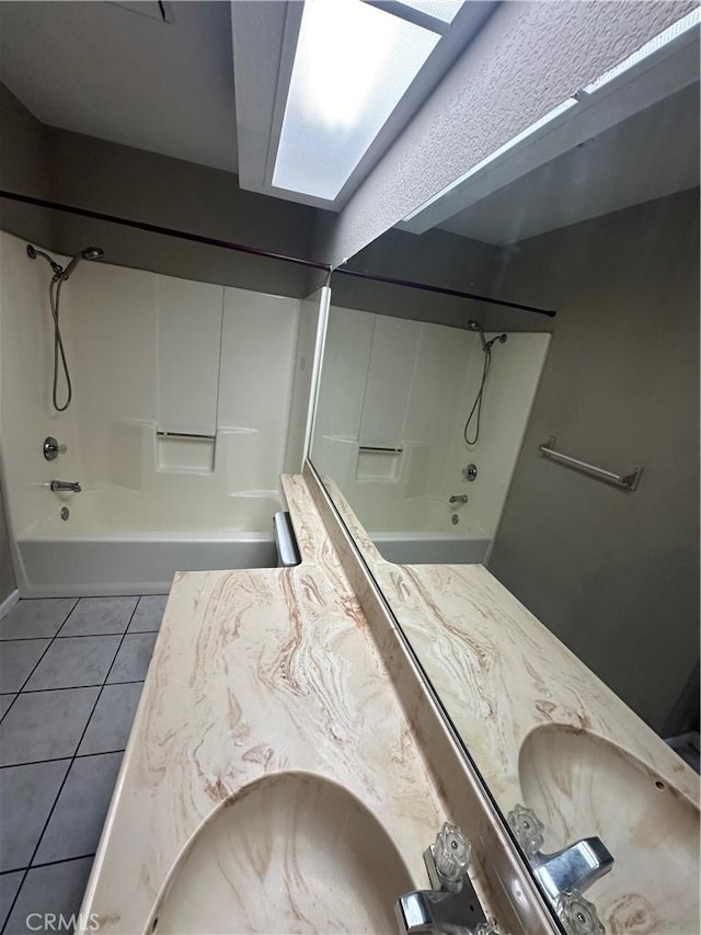 full bathroom featuring washtub / shower combination, tile patterned flooring, a sink, and double vanity