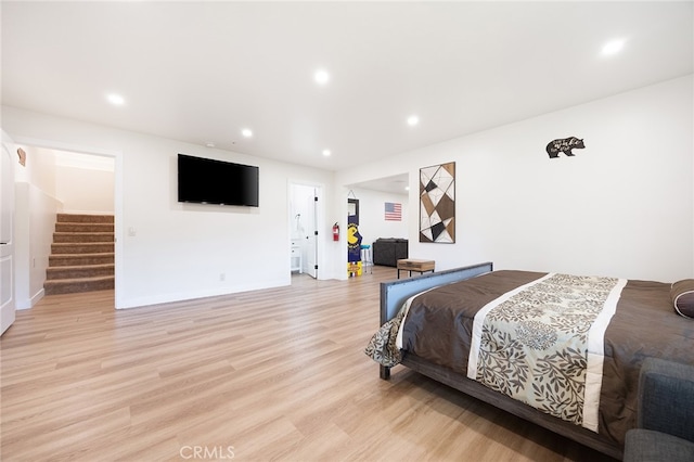 bedroom with connected bathroom and light wood-type flooring